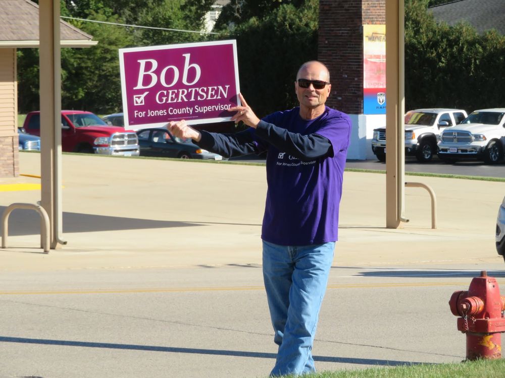 Bob Gertsen pointing to one of his campaign signs downtown