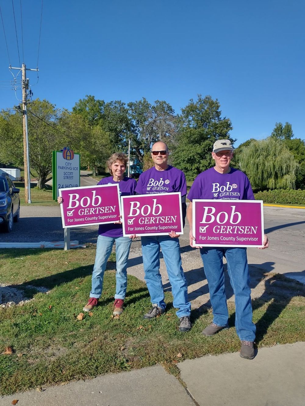 Supporters holding campaign signs on a roadside