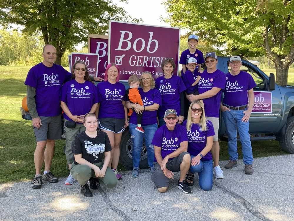Bob Gertsen with volunteers in campaign t-shirts in front of a large yard sign